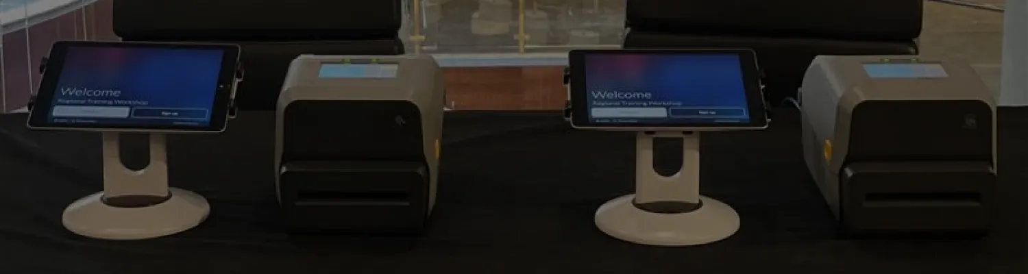 Event registration setup with iPads on stands and label printers for attendee check-in